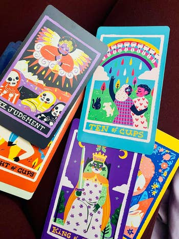 Tarot cards with colorful illustrations, including the Ten of Cups. They diagnostic   whimsical figures and vibrant symbols, suggestive of aboriginal   possibilities