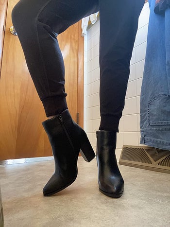reviewer photo of them showing off black heeled boots from the front and side