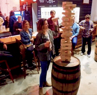 gif of adults playing the game on top of a barrel