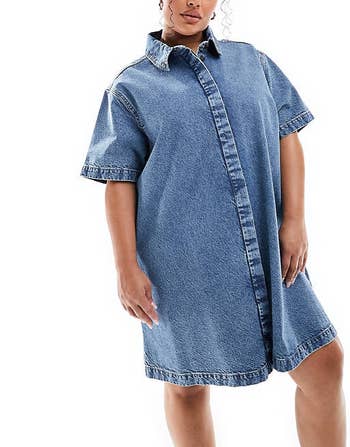 A model dressed in a denim dress with a frilled collar and button front