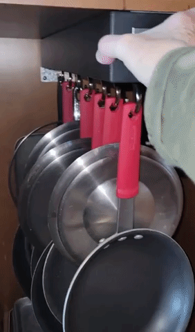 Video of reviewer sliding open pot and pan organizer inside cabinet