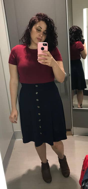 Reviewer wearing dress with burgundy top and black skirt