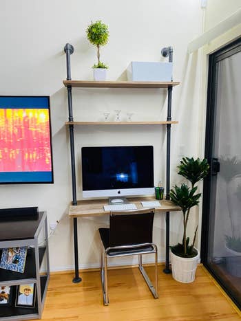 reviewer's wall-mounted desk holding iMac computer