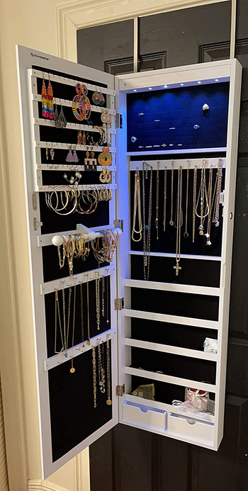 the same reviewer shows the inside of the storage mirror with jewelry hanging