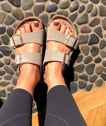 reviewer's feet wearing the beige sandals