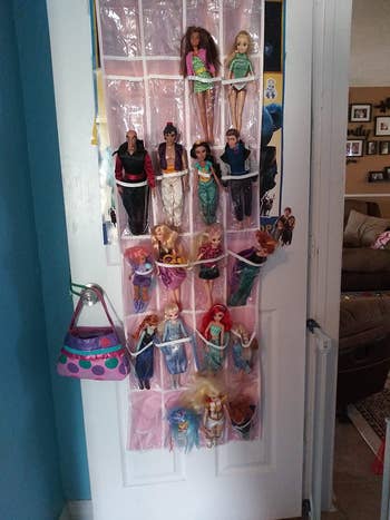 Reviewer's photo showing their kid's Barbie dolls stored in the shoe organizer