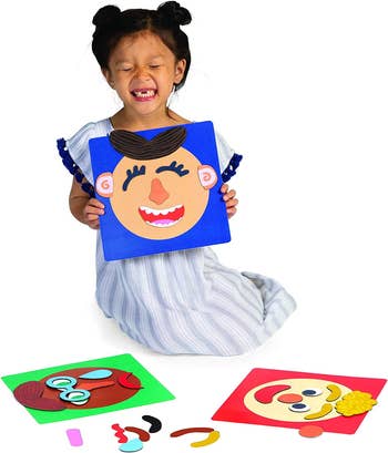 a child holding the face making set