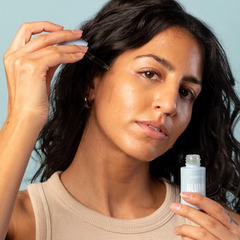 model applying the acne oil to their cheek