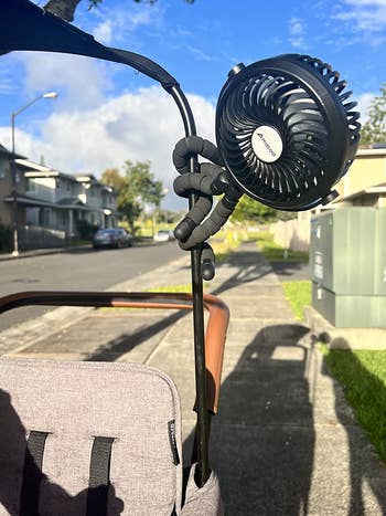 reviewer photo of the black fan wrapped around a kid's wagon