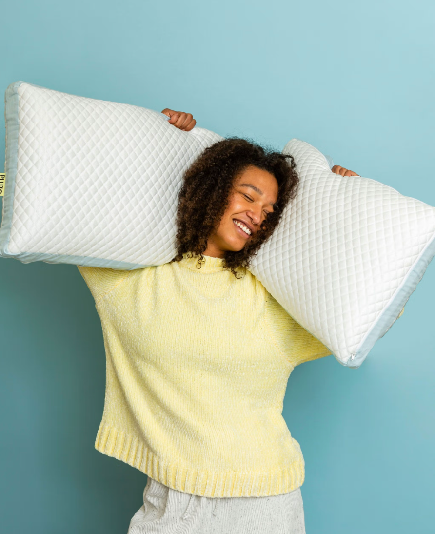model smiling and holding up   2  pillows successful  antithetic  sizes
