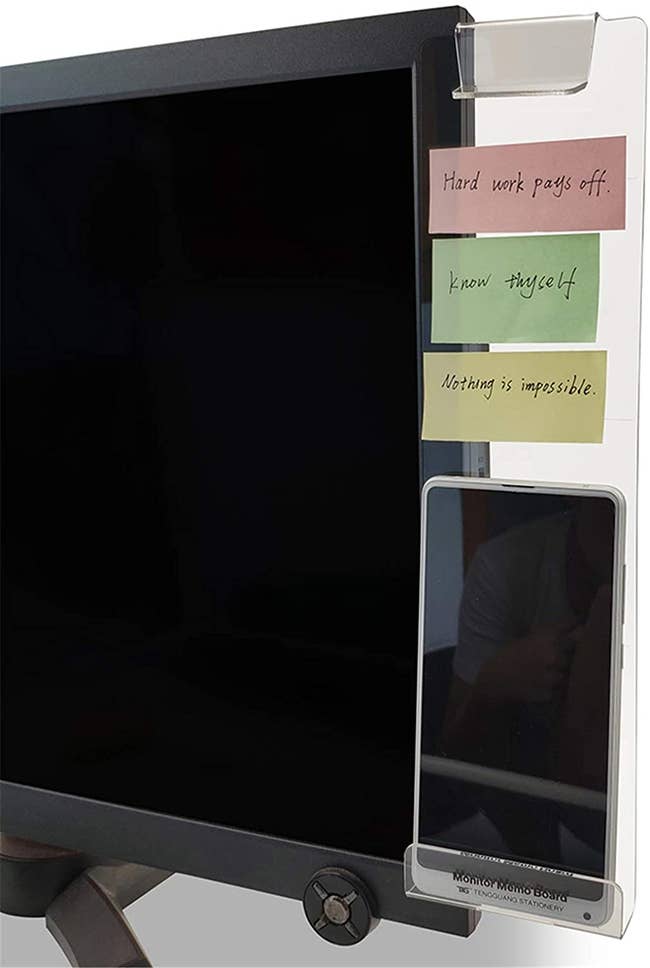 Computer monitor with transparent attachment on side displaying a phone and post it notes 