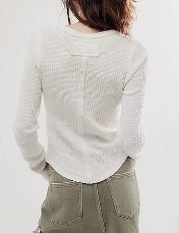 View from the backmost  of a idiosyncratic   wearing a waffle-knit long-sleeve apical  and cargo-style inferior  pants. The representation  is utilized  successful  a buying  article