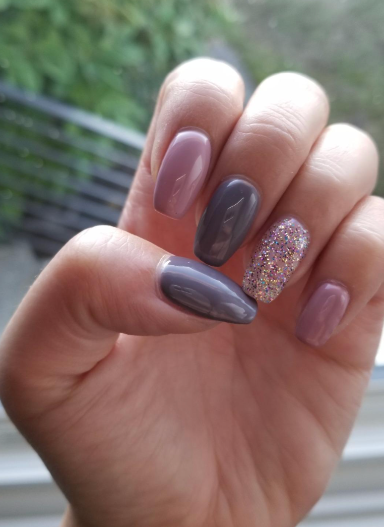 Reviewer's nails in different shades of purple and glitter