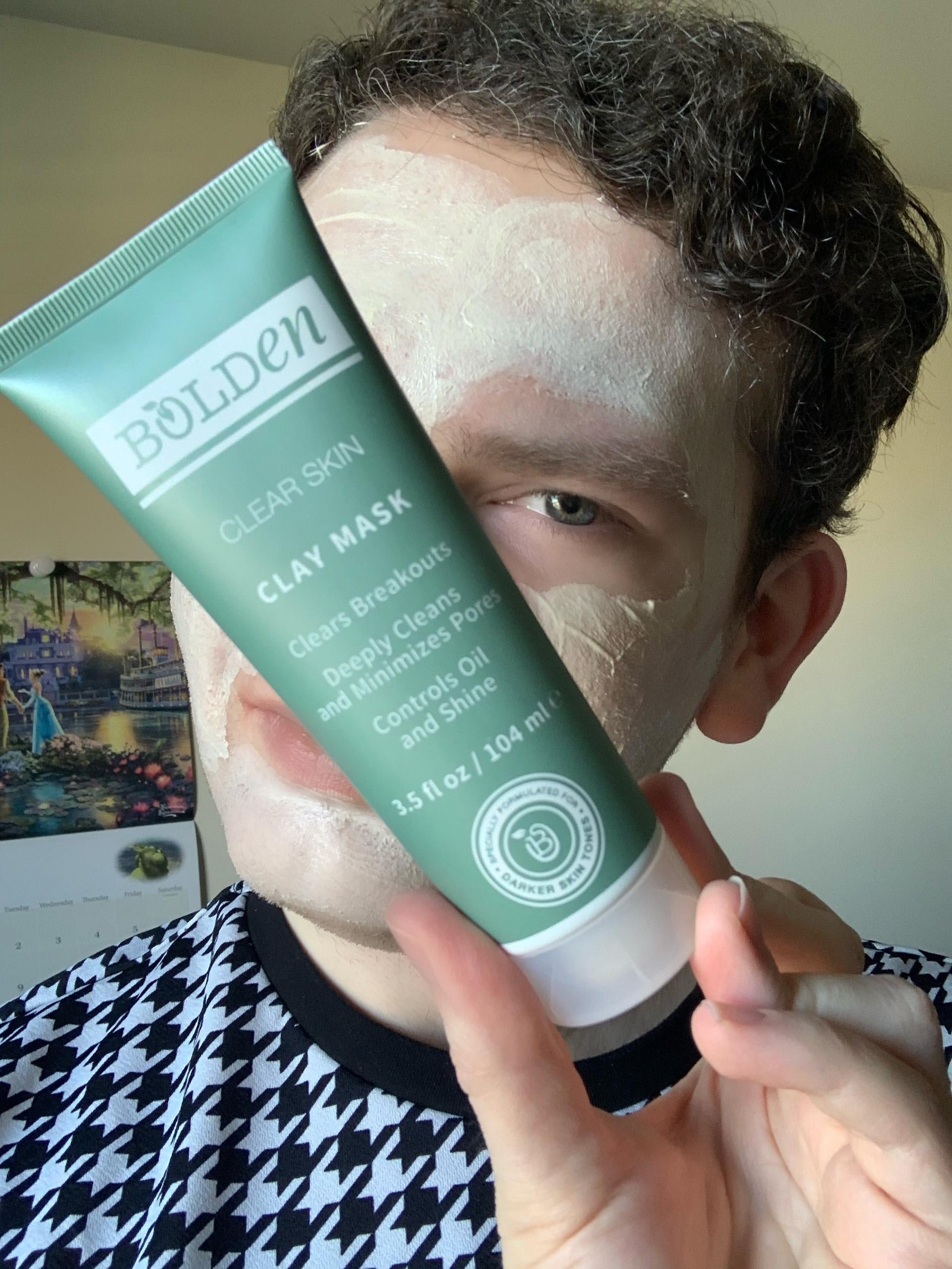 BuzzFeeder holding bottle of Bolden clay face mask