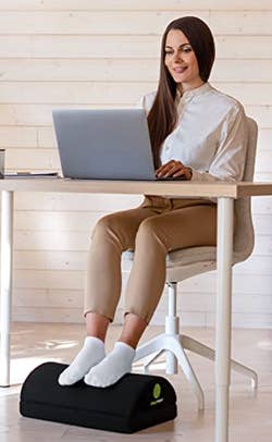 A model sitting at a desk with their feet resting on the curved side