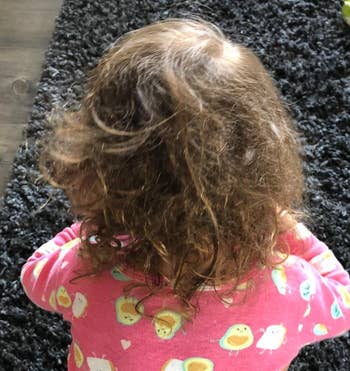 Reviewer's before photo showing their child's messy hair before using the spray 