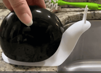 gif of a reviewer pressing down on the black snail soap dispenser to show what the soap looks like coming out