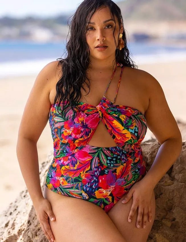 model wearing pink and purple tropical-printed bathing suit