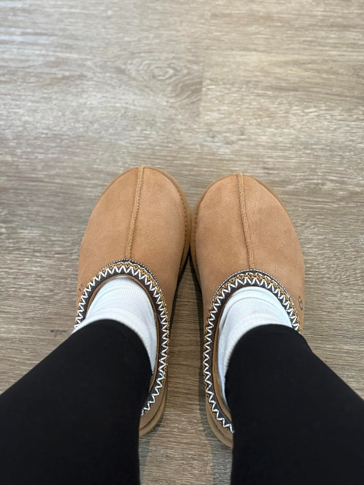 Top-down presumption    of idiosyncratic   wearing achromatic  leggings and achromatic  socks with Ugg Tasman II slippers successful  tan suede