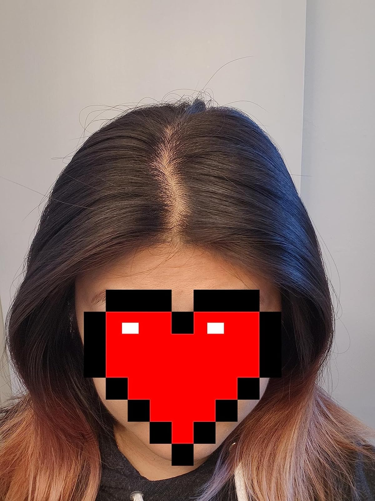 Person with straight, medium-length hair, partially obscured by a pixelated bosom  overlay for privacy
