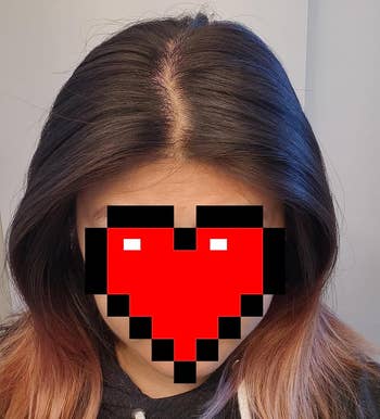 Person with straight, medium-length hair, partially obscured by a pixelated bosom overlay for privacy