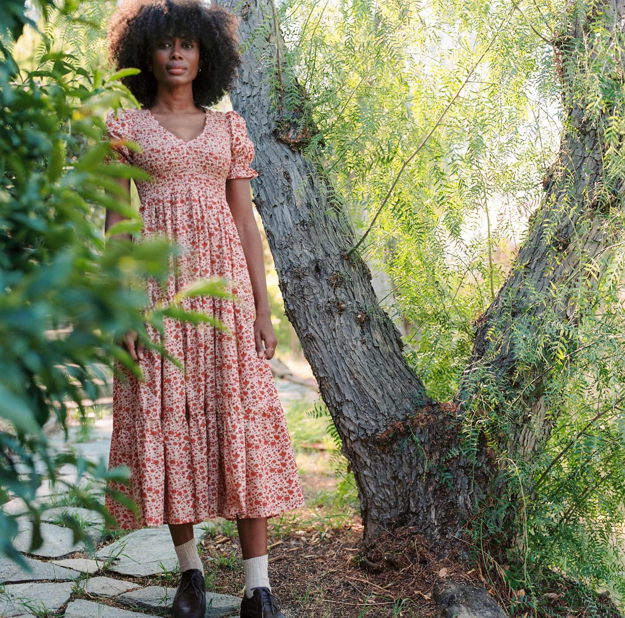 a model in a pink and orange floral dress with puffy sleeves