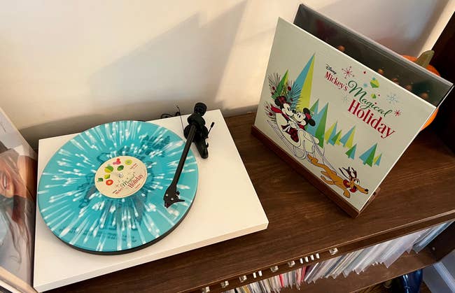 a blue and white splattered record next to the vinyl sleeve of mickey's magical holiday