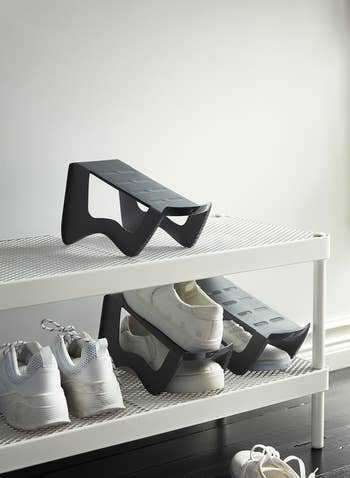 Shoe retention  rack with respective  pairs of achromatic  sneakers, featuring a modern, minimalist plan  for businesslike  organization