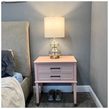 reviewer photo of light pink nightstand with lamp on it
