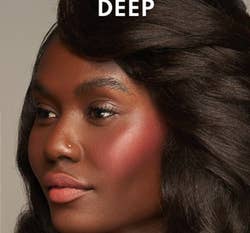 Close-up of a model showcasing shimmering blush on her cheeks, suitable for deep skin tones, likely for makeup shopping