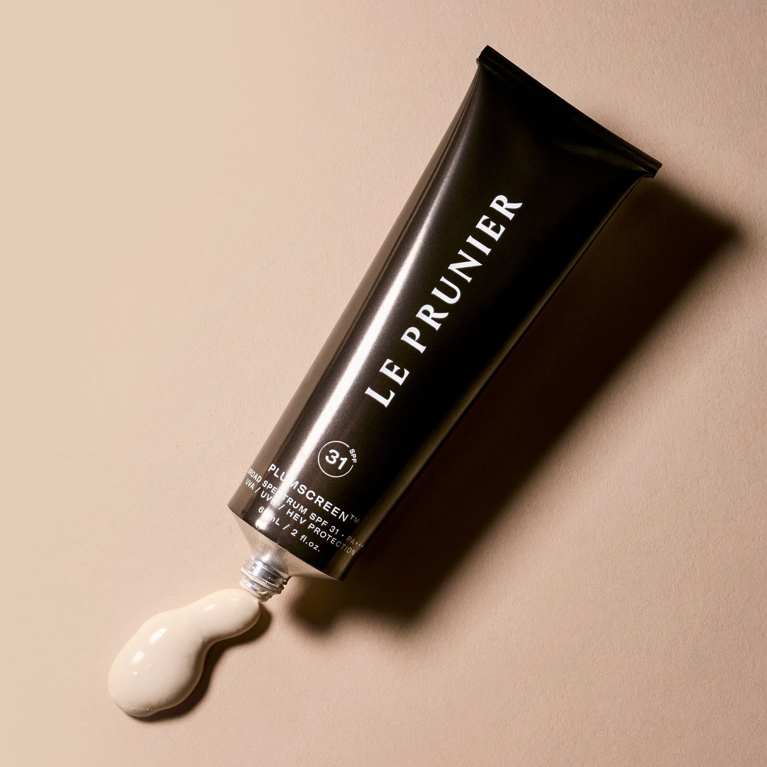 the jar of sunscreen with a bit of product squirting out