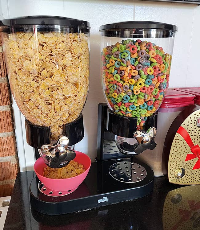 a black cereal dispenser with two types of cereal in each side