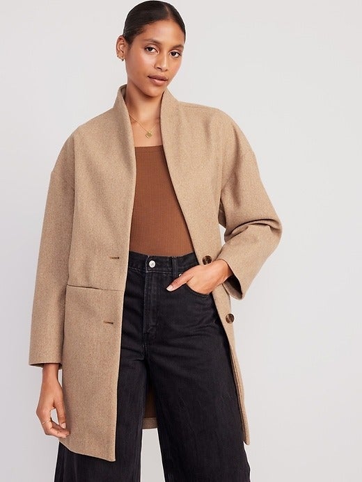 a model in a tan long line coat