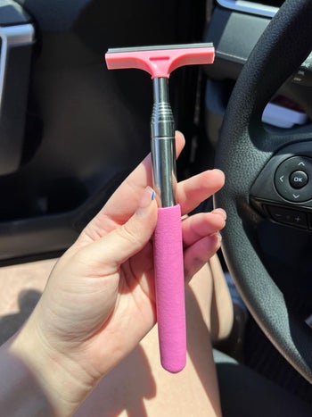 reviewer holding a pink-handled window wiper