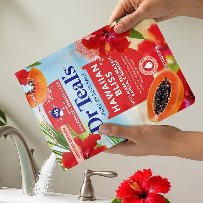 Hands pouring Dr Teal's Hawaiian Bliss Epsom Salt into a bathtub