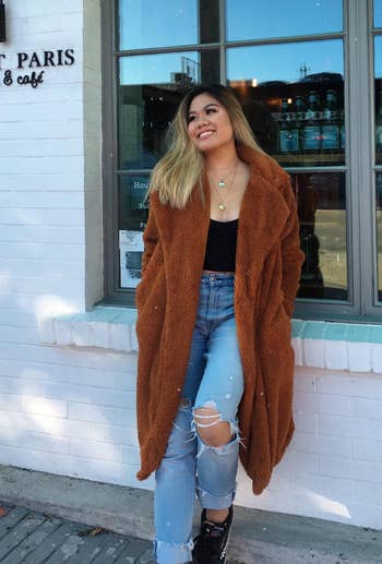 reviewer wearing the jacket in camel with jeans and a black top