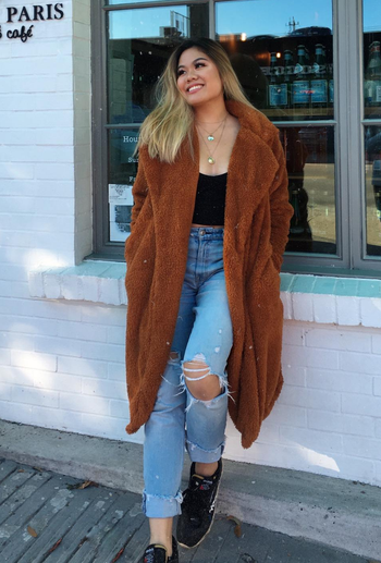 reviewer wearing the jacket in camel with jeans and a black top