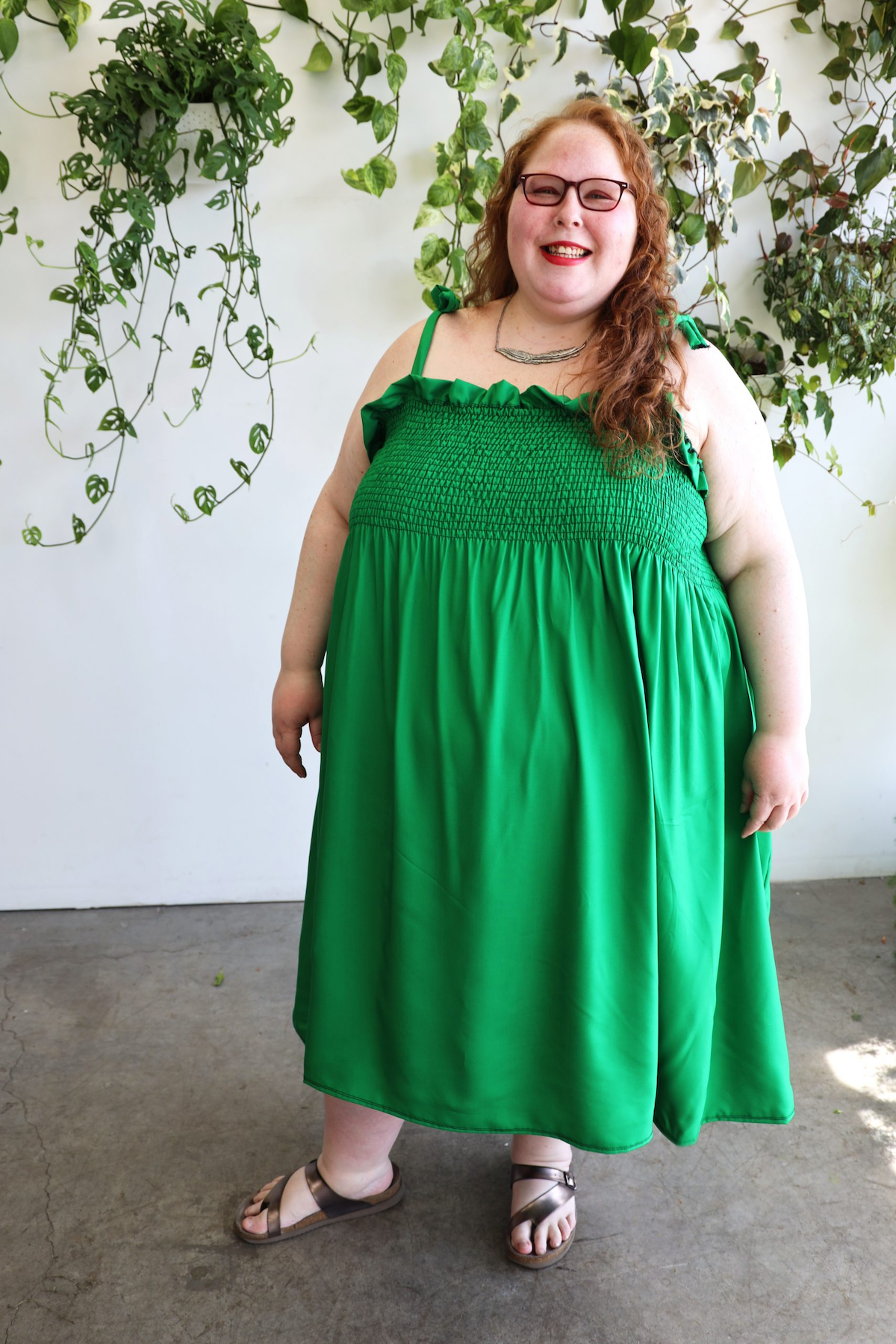 a model wearing the green ankle length dress with tie straps 