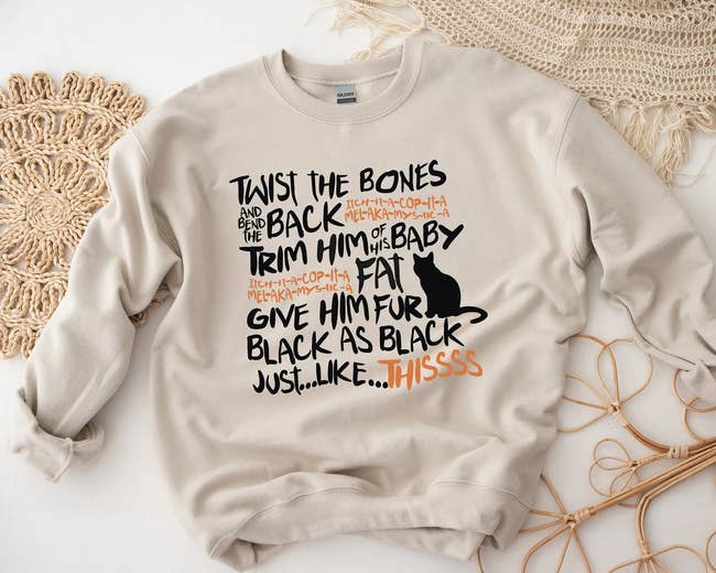 Sweatshirt with a playful design featuring a cat silhouette and whimsical text 