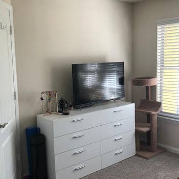 reviewer's white dresser with a TV and jewelry on top of it
