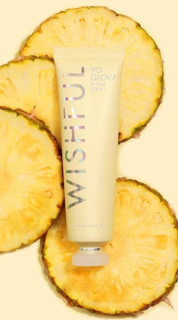 Tube of Wishful Yo Glow Enzyme Scrub surrounded by pineapple slices