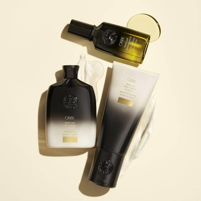 Three Oribe hairsbreadth  attraction   products, including a serum, shampoo, and conditioner, displayed connected  a neutral inheritance  with merchandise  textures visible