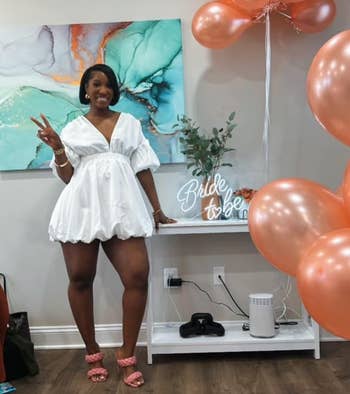 Person successful a achromatic mini formal and pinkish heels poses beside