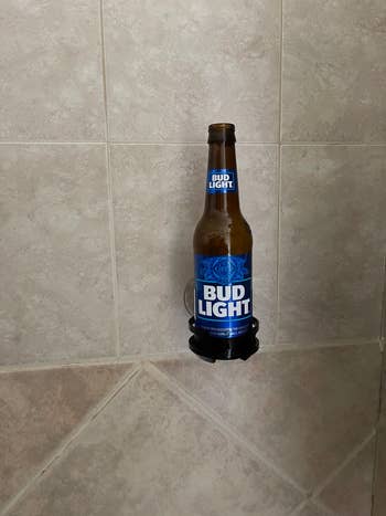 A reviewer's beer suctioned to their shower wall