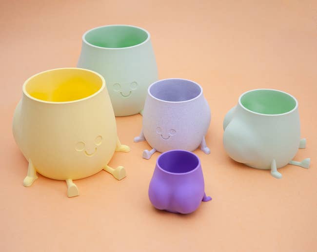 yellow green and purple butt planters with smiley faces