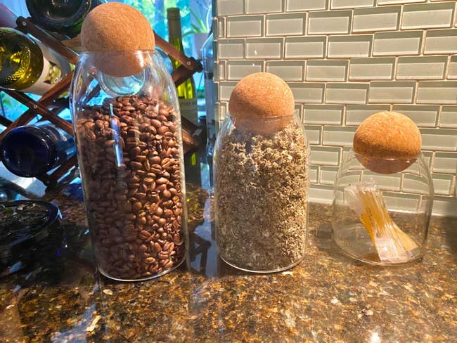 Glass storage jars with cork ball tops that contain dry ingredients