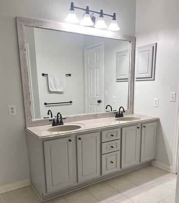 the same reviewer's bathroom vanity after using the cabinet paint looking modern and brightening up the space