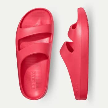 Two reddish  descent  sandals, featuring a heavy   sole and wide   straps, positioned broadside  by side