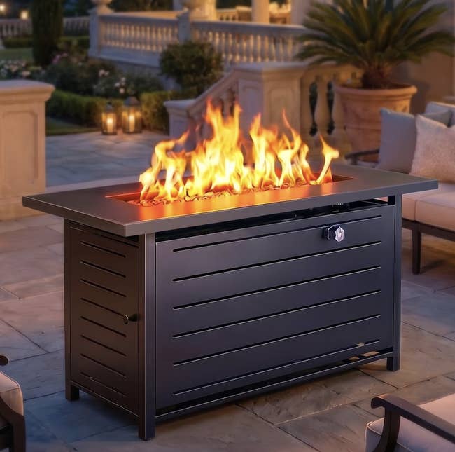 Outdoor occurrence pit array with modern design, acceptable connected a patio astatine dusk, flames flickering connected top, surrounded by elegant outdoor furniture