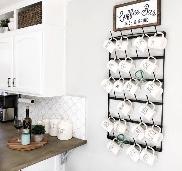 reviewer image of the black rack hung on wall holding tons of mugs